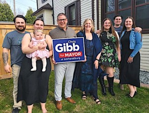 Photo of Chris Gibb with family and his mayoral election campaign sign.